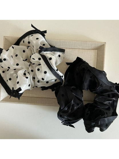 Close-up of Gifty elegant bow tulle scrunchie in soft pink on white background
