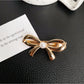 Beau classic bow hair clip in cream color displayed with matching accessories