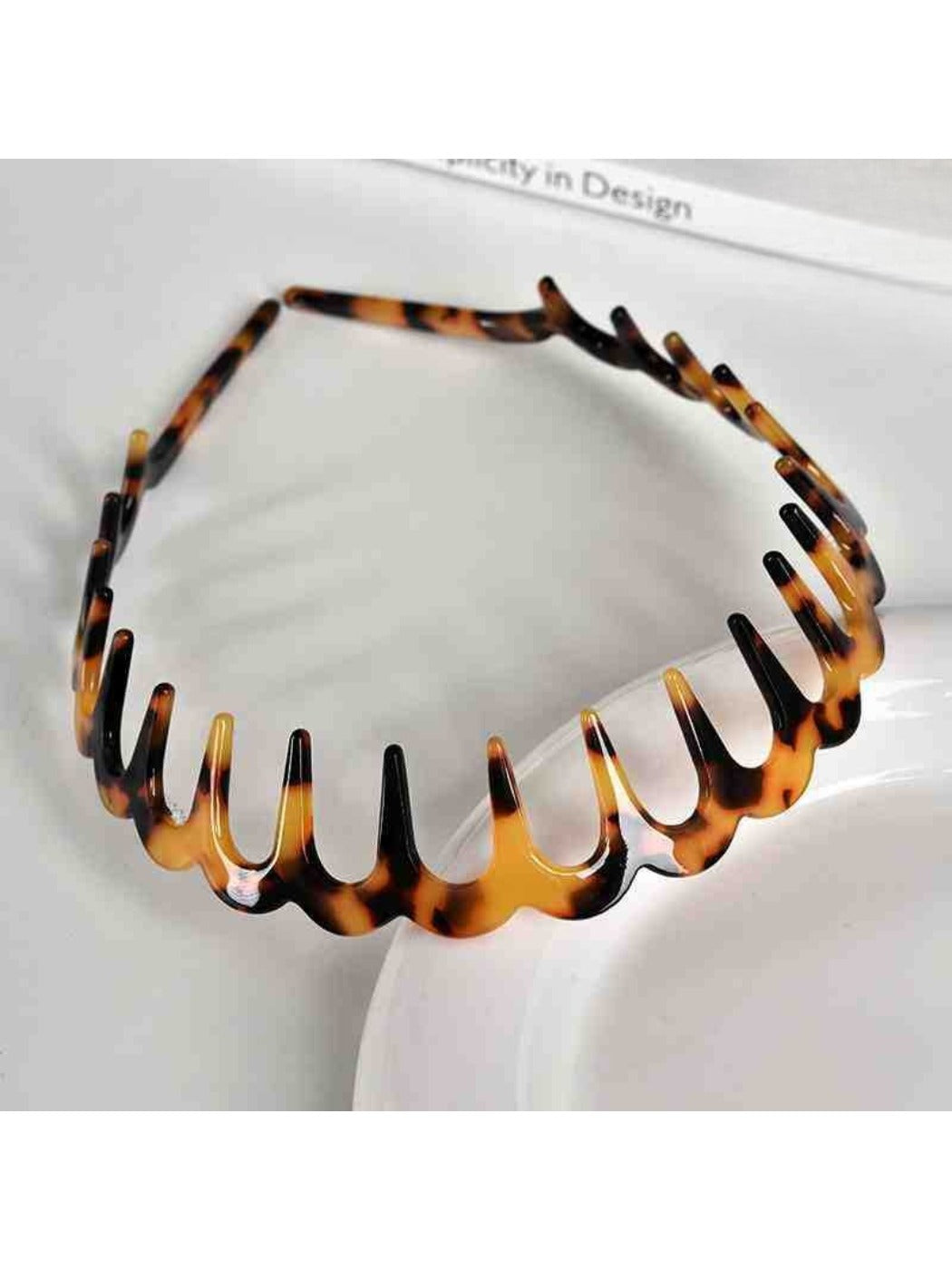 Side view of Gifty wavy headband highlighting curved teeth and glossy finish