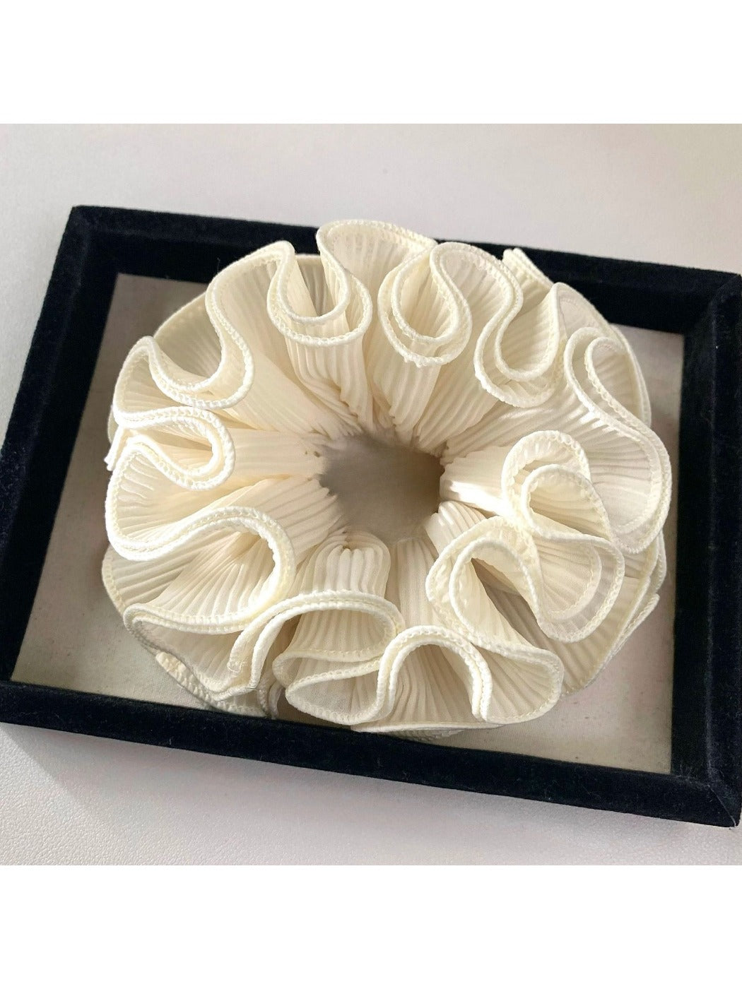 Gifty ruffle scrunchie worn on a wrist as a fashion accessory