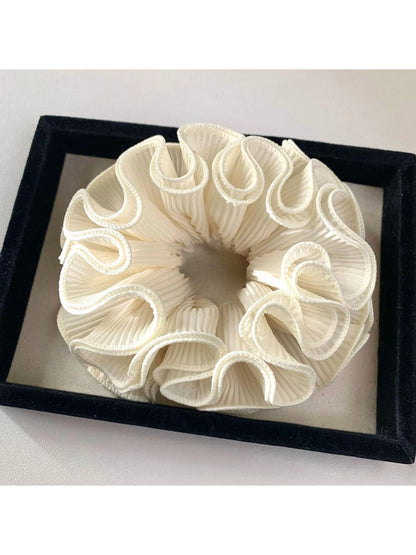 Gifty ruffle scrunchie worn on a wrist as a fashion accessory