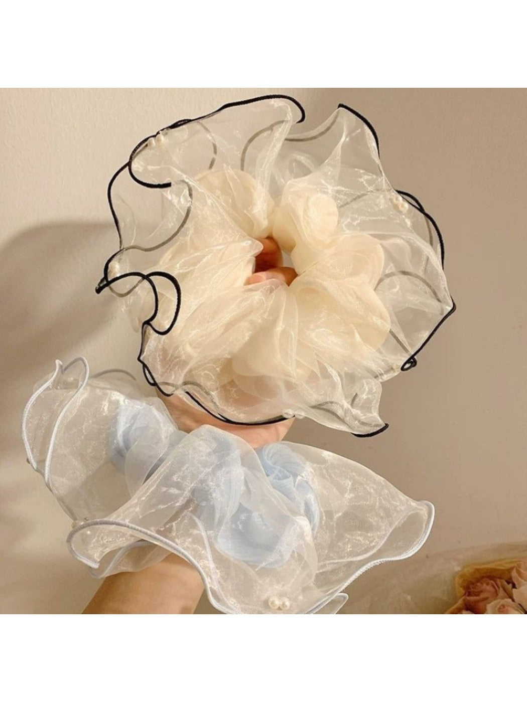Close-up of elegant beige tulle scrunchie with delicate texture on white background
