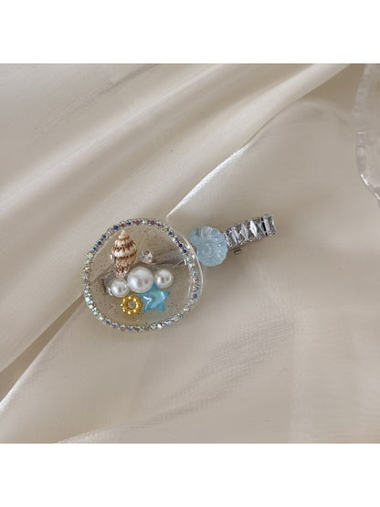 Beau hair clip styled in long hair, showcasing its decorative conch shell feature