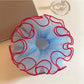 Blue tulle scrunchie with red trim on a white background