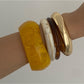 Close-up of Lovra wide round bangle bracelet highlighting its rounded edges and shiny finish