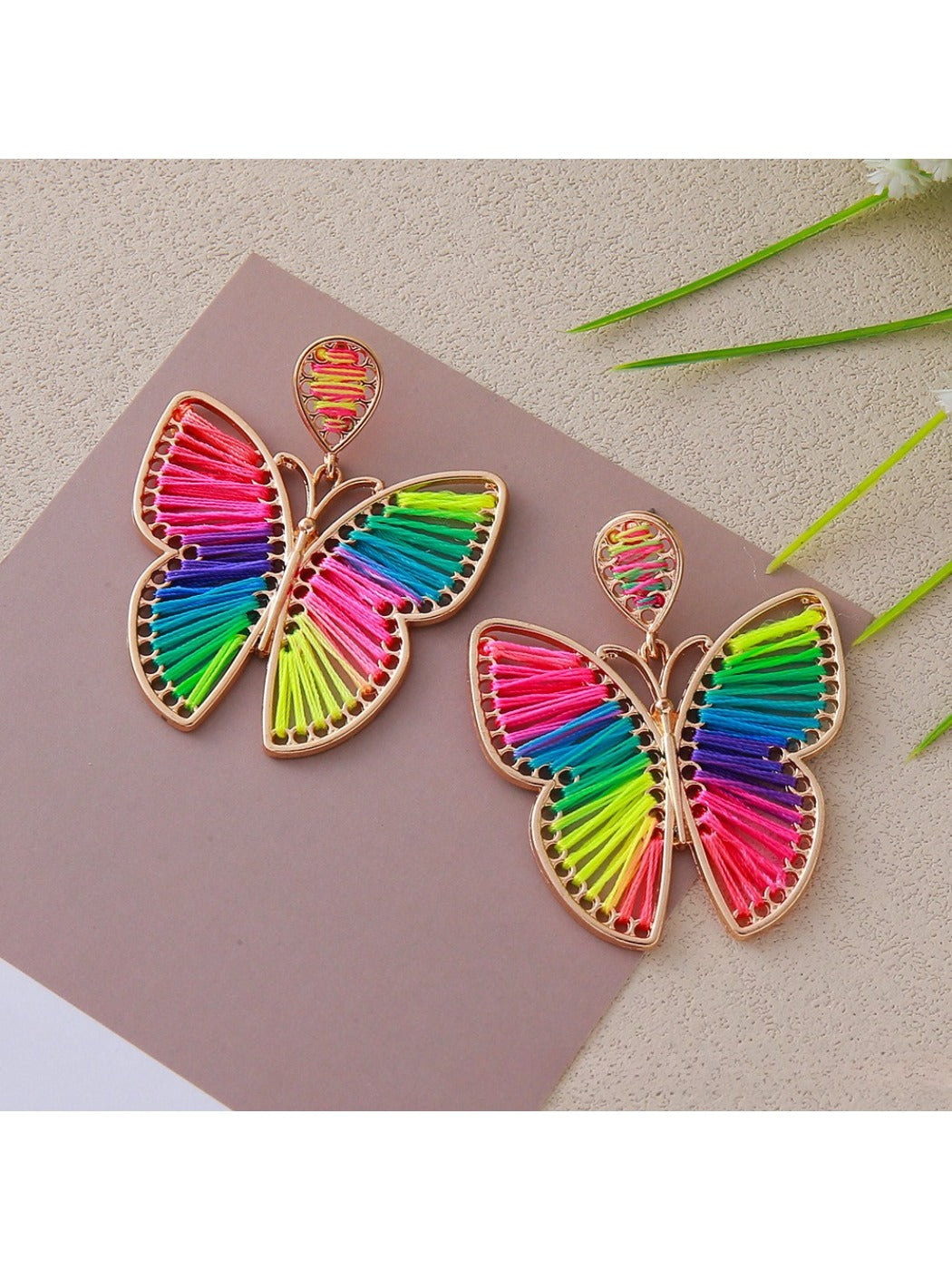 Model wearing Earedge butterfly shaped drop earrings with a soft smile