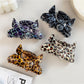 Beau claw clip showing leopard print pattern and butterfly detail from side angle