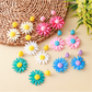 Close-up of Bohemian daisy floral raffia stud earrings on white background