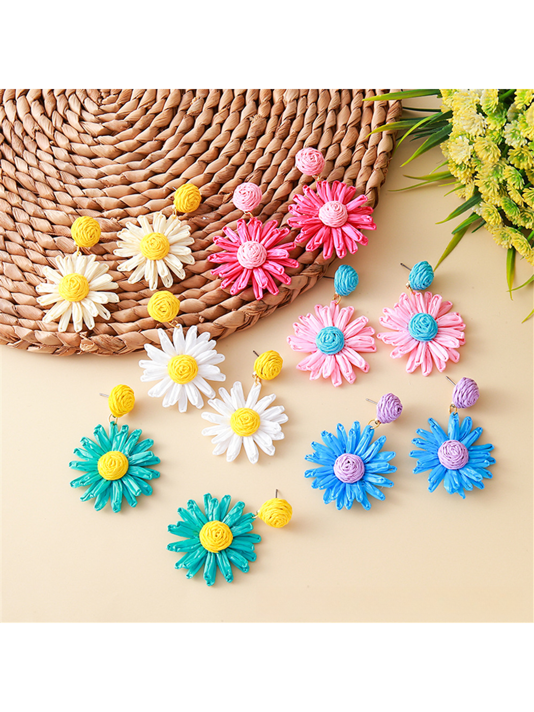 Close-up of Bohemian daisy floral raffia stud earrings on white background
