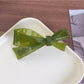 Beau acetate bow hair clip held in hand to show size and shape