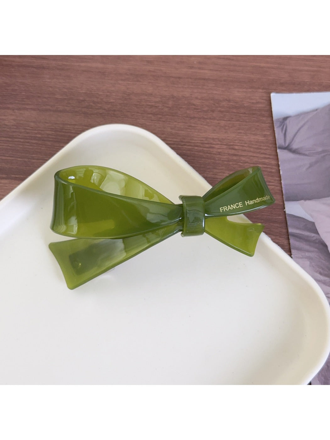 Beau acetate bow hair clip held in hand to show size and shape