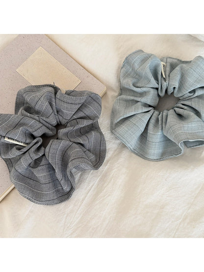Close-up of vintage minimalist stripe scrunchie in neutral tones on white background