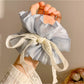 Lavender purple Gifty bow scrunchie styled in a ponytail on a model's hair