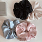 Close-up of Gifty rhinestone decor satin scrunchie in soft pink with sparkling rhinestones