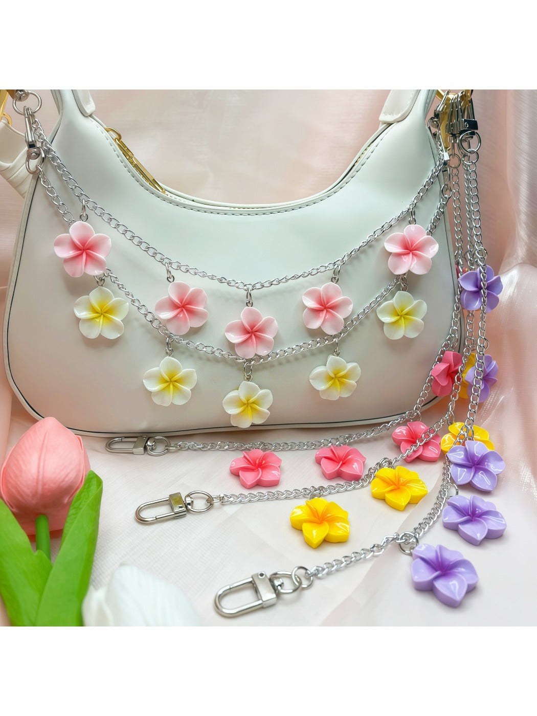 Flower pendant bag charm attached to a beige handbag handle