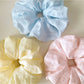 Gifty colorful checkered scrunchie with vibrant red, blue, and yellow pattern on fabric