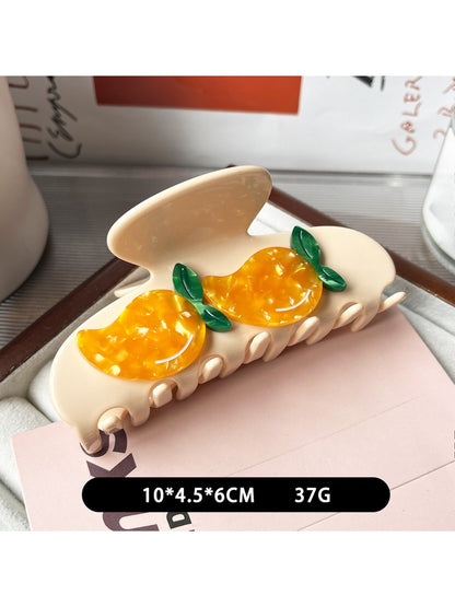 Close-up of yellow fruit shaped claw clip showing smooth finish