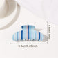 Beau half moon claw clip placed on wooden surface with natural light