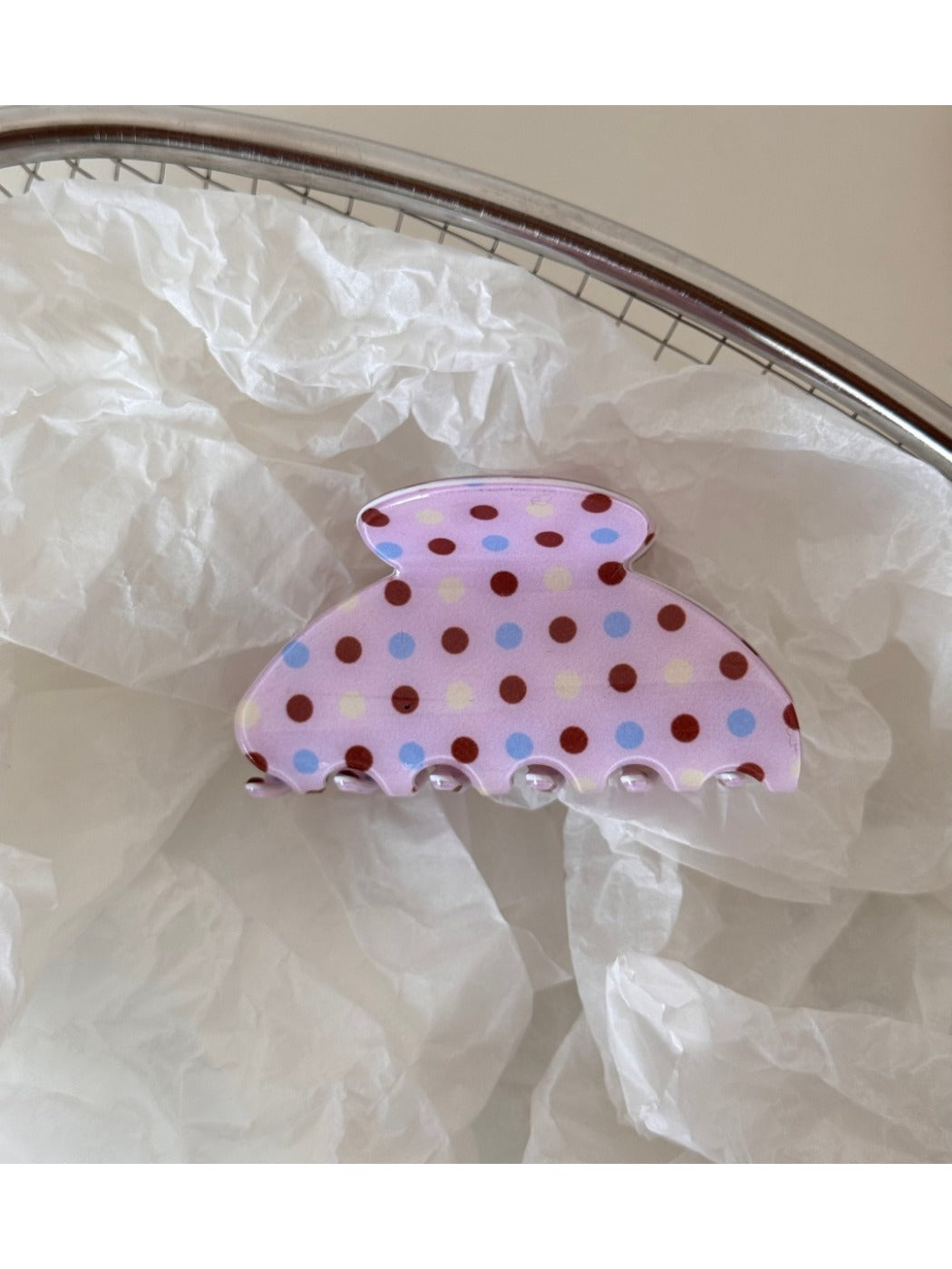 Beau pink hair clip with white polka dots next to matching pink accessories