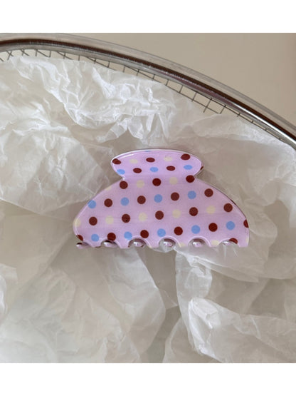 Beau pink hair clip with white polka dots next to matching pink accessories