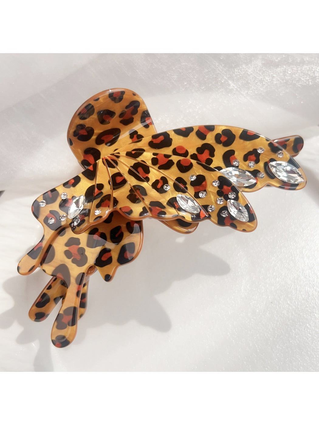 Beau butterfly claw clip with leopard print placed on wooden surface