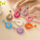 Close-up of Earedge Bohemian geometric raffia drop earrings on white background