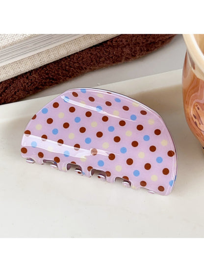 Beau crescent pink claw clip with white polka dots angled to show clip curvature