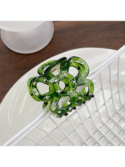 Beau flower shaped hair claw clip held in hand showing size and details