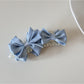 Beau satin bow banana clip in soft pink satin fabric on white background