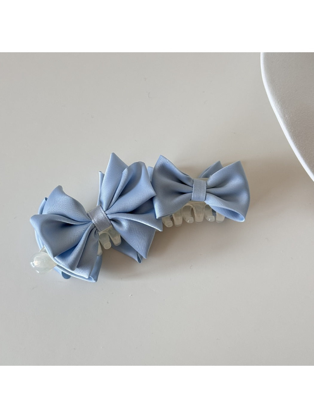 Beau satin bow banana clip in soft pink satin fabric on white background