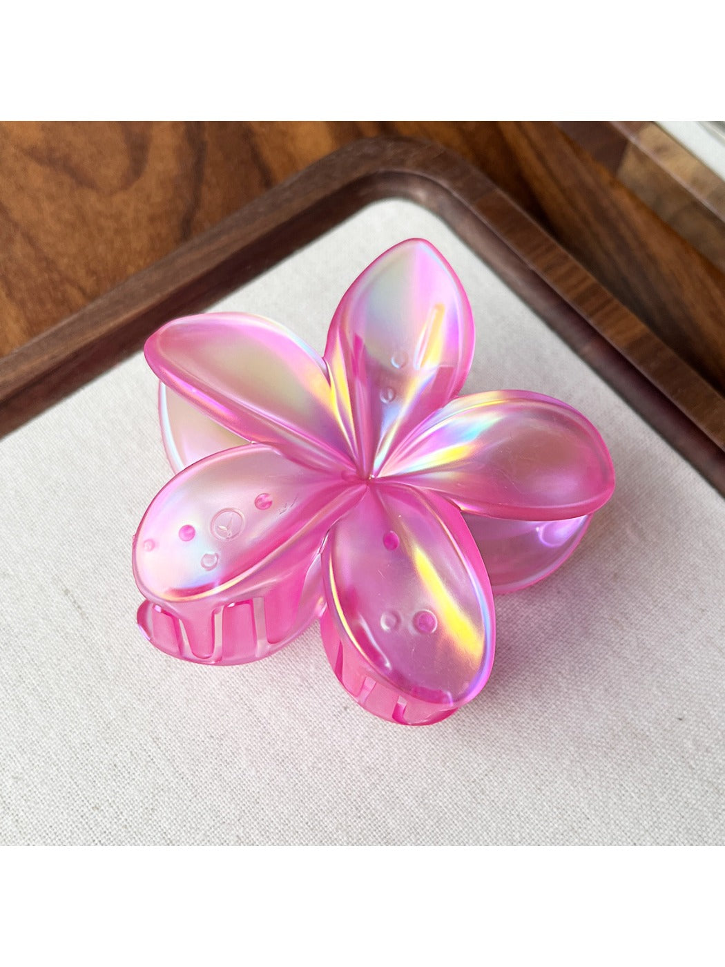 Beau flower shaped claw clip shown from bottom angle revealing clip teeth