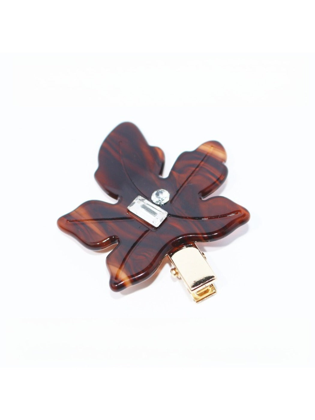 Beau leaf hair clip positioned on a wooden surface with natural light