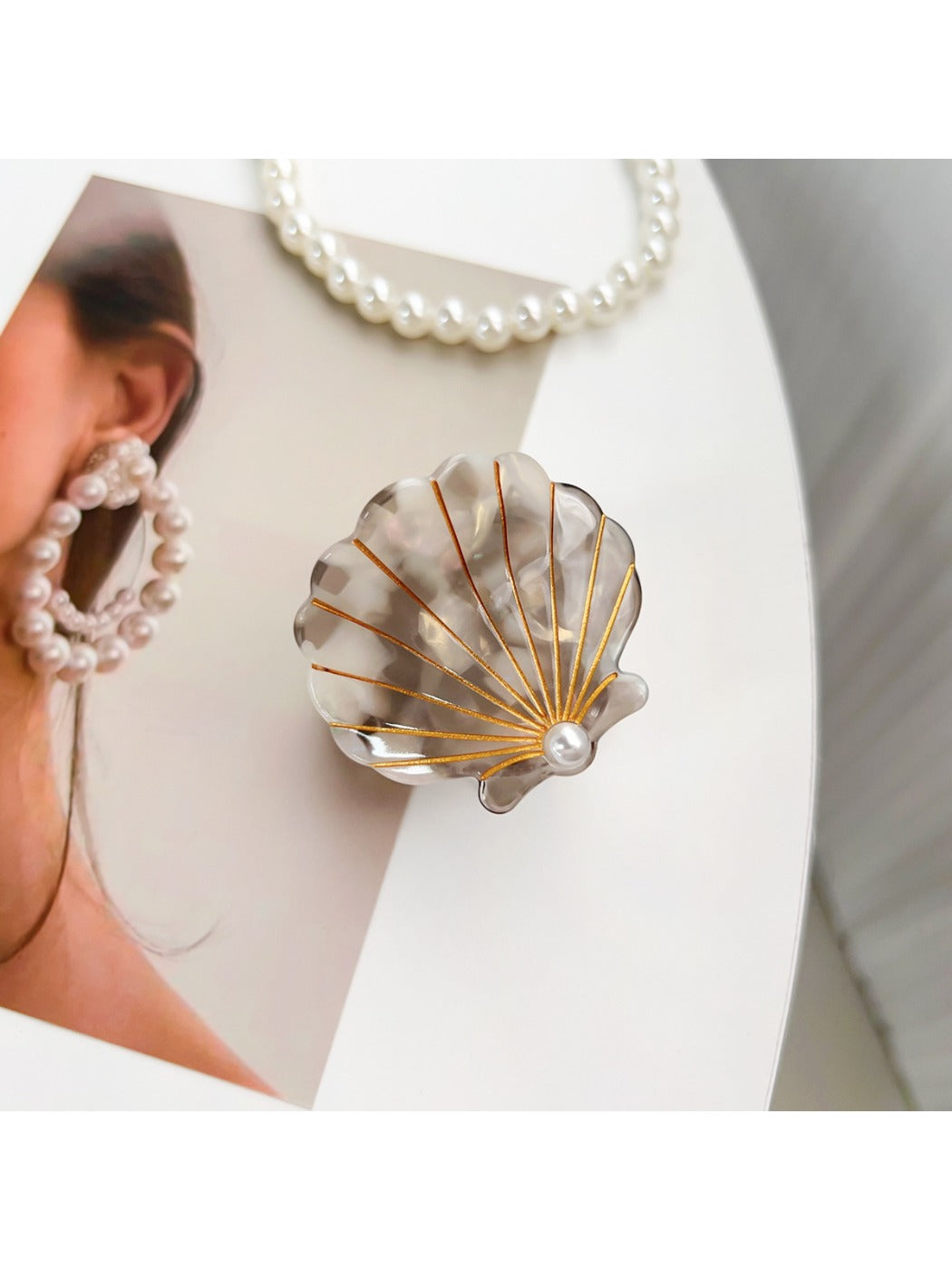 Beau shell shaped hair claw clip photographed with soft shadows