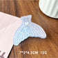 Beau claw clip positioned diagonally showing detailed ocean wave design