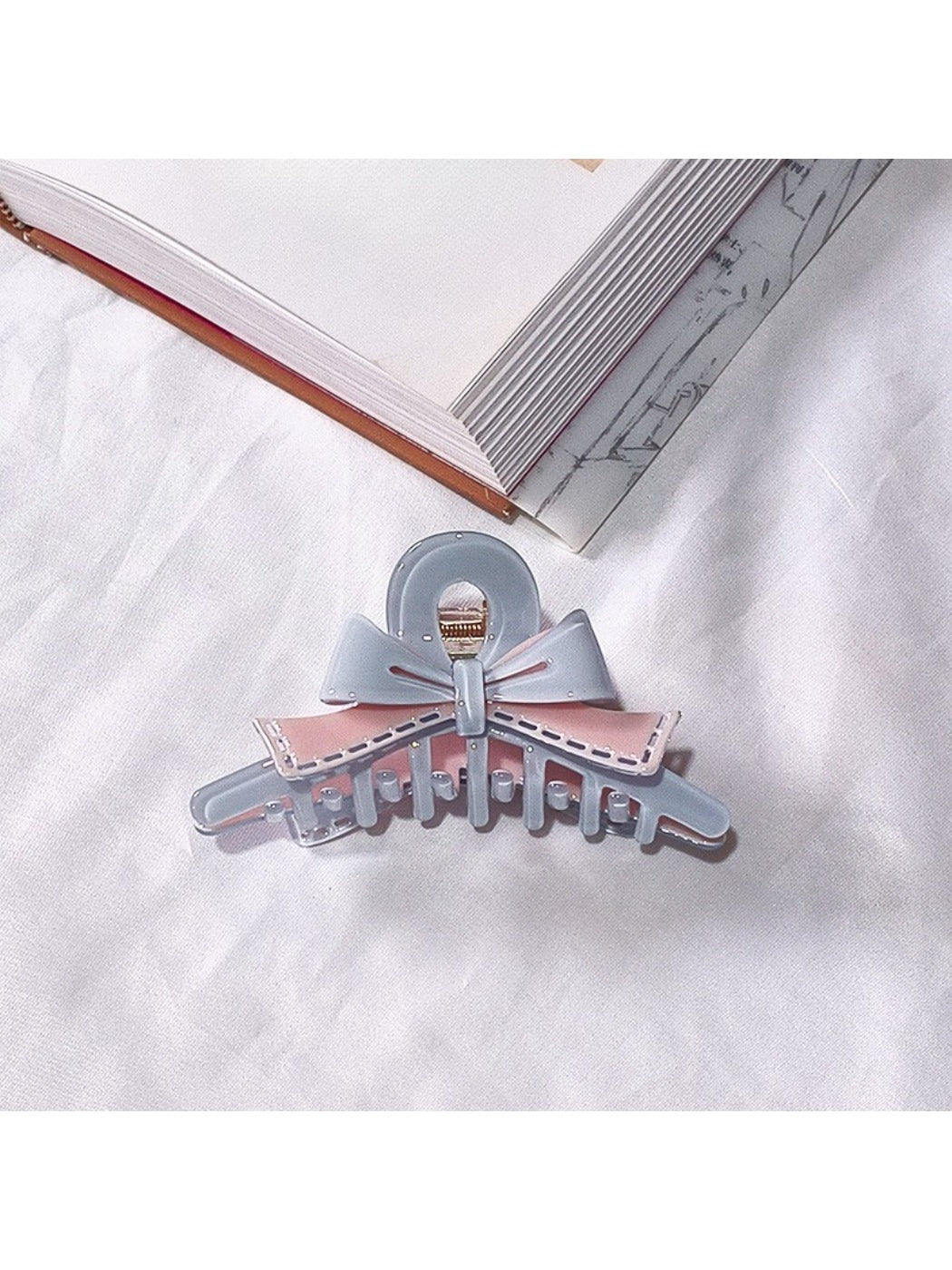 Beau acetate bow shaped claw clip displayed with complementary hair colors