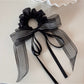Gifty scrunchie worn in hair, showcasing its volume and layered ribbons