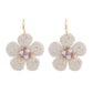 Earedge raffia flower earrings worn on a model showcasing size and natural color