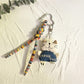 Trendy cat charm keychain displayed alongside other silver accessories