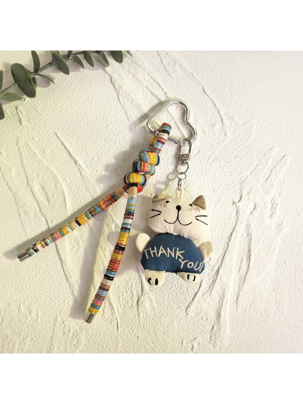 Trendy cat charm keychain displayed alongside other silver accessories