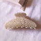 Beau chic tiny floral acetate claw clip angled to show translucent acetate material