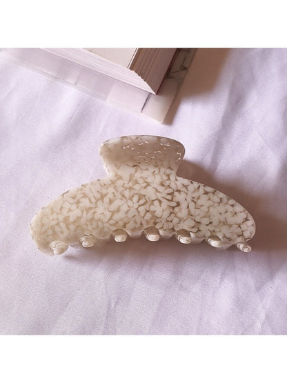 Beau chic tiny floral acetate claw clip angled to show translucent acetate material