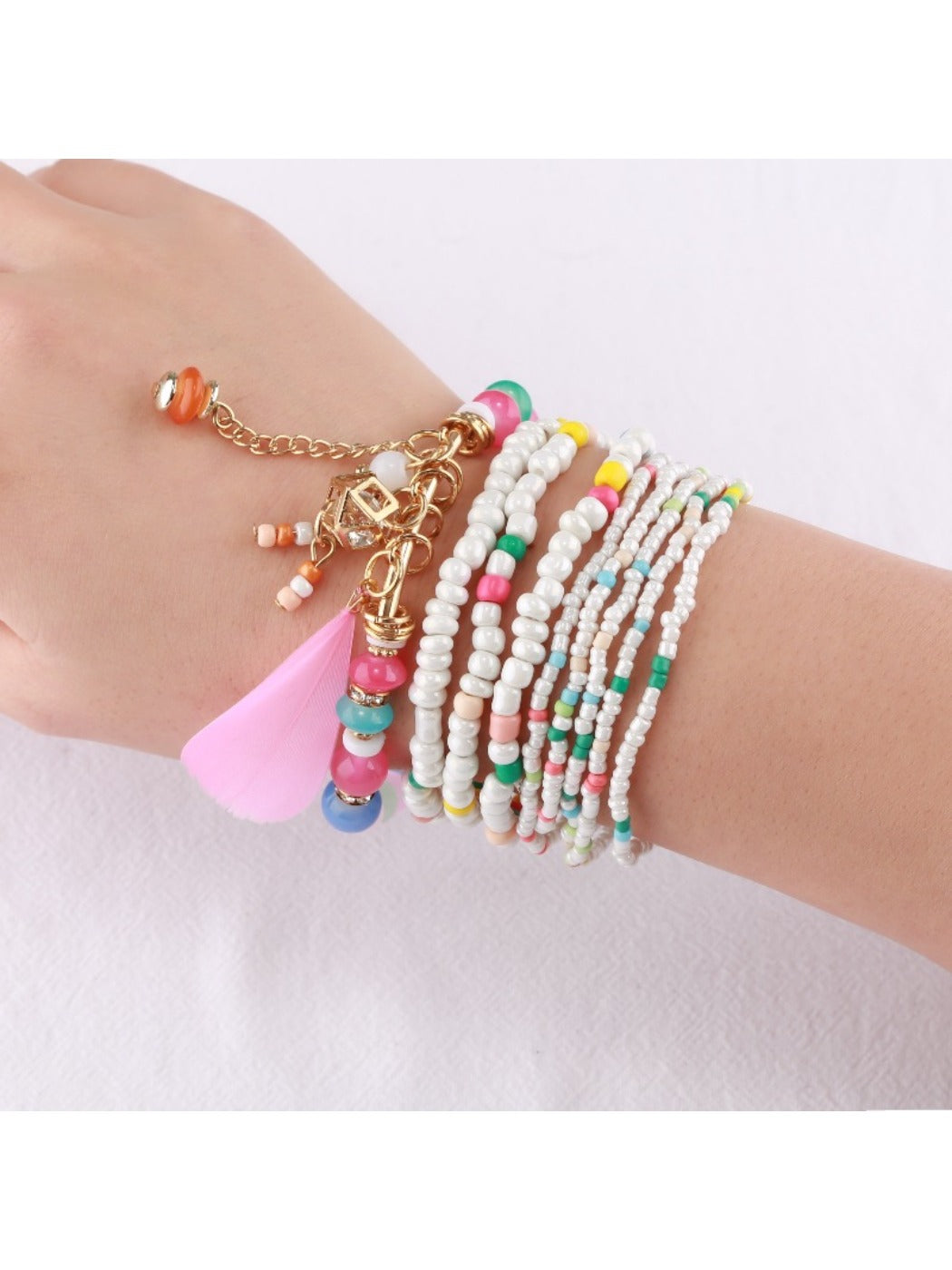 Model wearing multiple Lovra stackable beaded bracelets on wrist with casual outfit