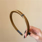 Flat lay of multiple Gifty satin headbands in various solid colors arranged neatly