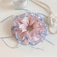 Close-up of pink bow print scrunchie showing fabric texture