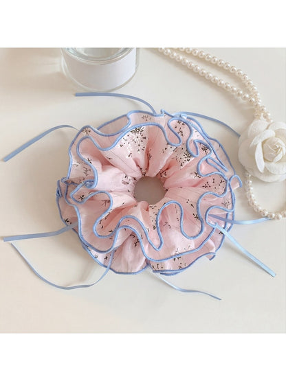Close-up of pink bow print scrunchie showing fabric texture