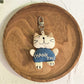 Cat charm keychain held between fingers showing size and detail