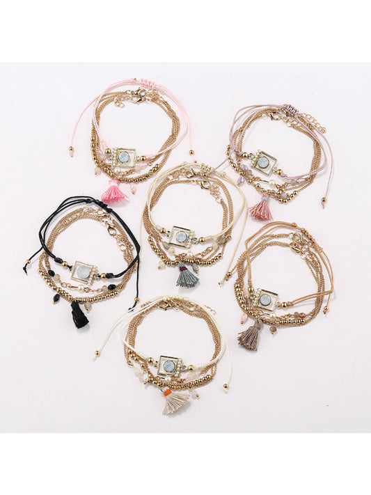 Close-up of Lovra tassel pendant with small beads on a delicate bracelet