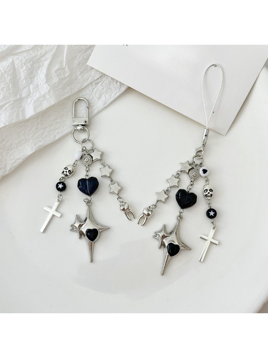 Silver cross-shaped keychain with smooth polished finish on white background