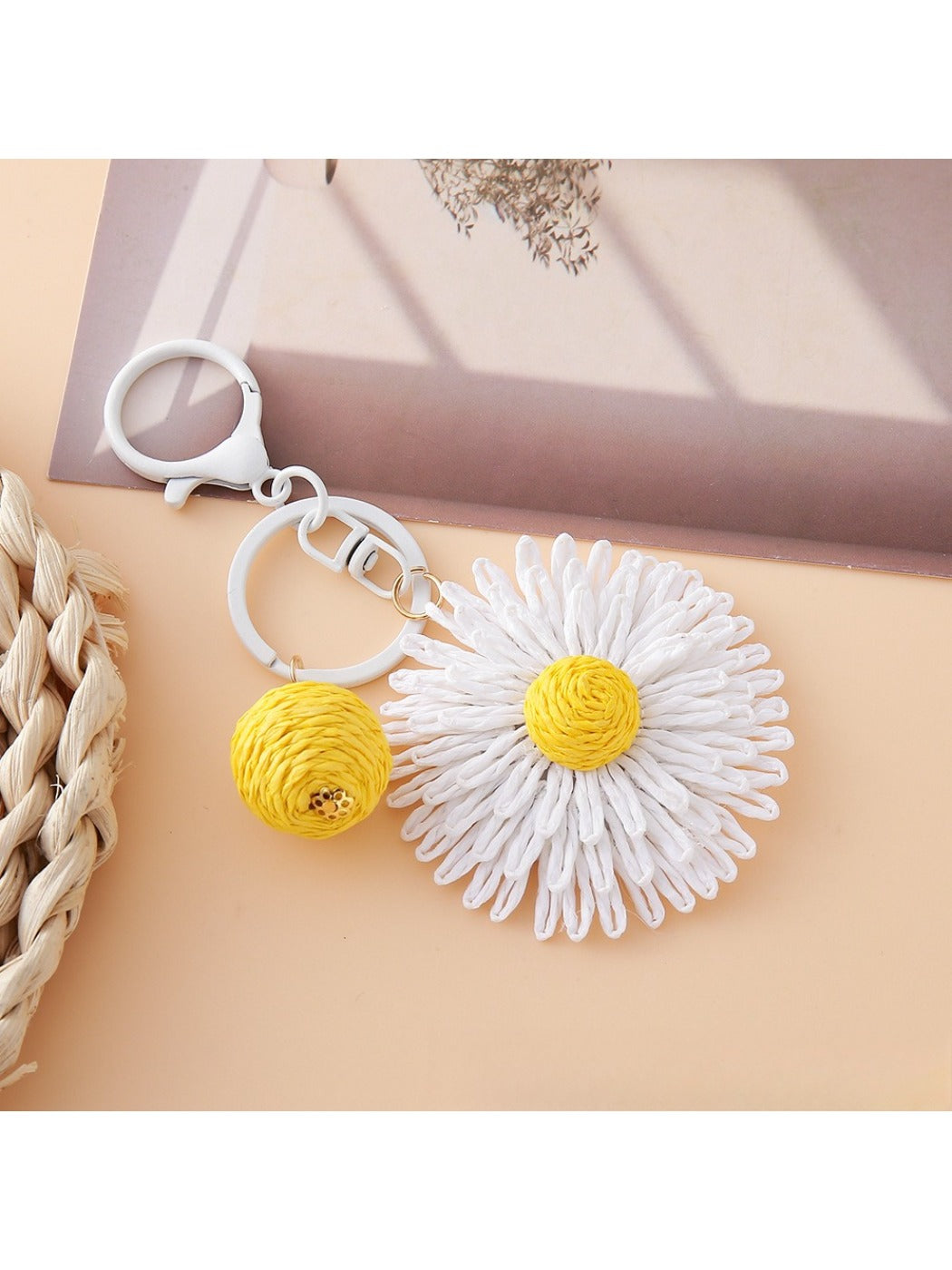 Side angle of raffia sunflower keychain highlighting texture and shape