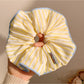 Yellow striped scrunchie styled with casual outfit on a model